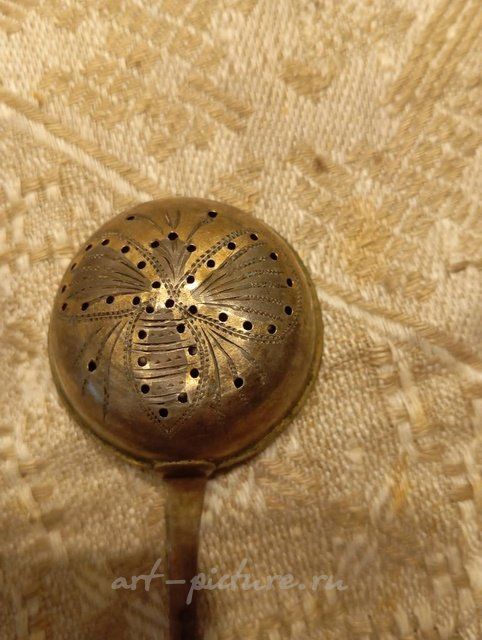 Antique silver strainer spoon with gilding.