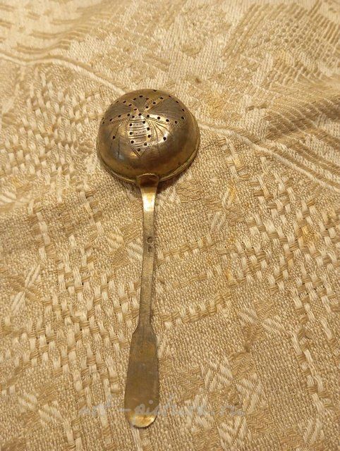 Antique silver strainer spoon with gilding.